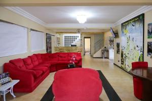 a living room with a red couch and red chairs at Diamantina Palace Hotel in Morro do Chapéu