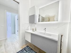 a white bathroom with a sink and a mirror at Milano Suite Francine in Milan +9 photos