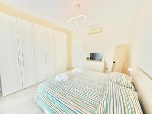 a bedroom with a bed with a striped blanket at Milano Suite Francine in Milan