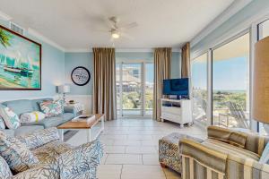 a living room with a couch and a tv at Conveniently located Gulf condo with spacious layout pool & pickleball in Seacrest