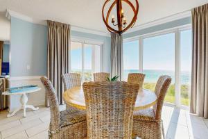 a dining room with a table and chairs and the ocean at Conveniently located Gulf condo with spacious layout pool & pickleball in Seacrest