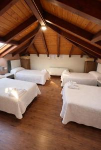a room with four beds in a room with wooden ceilings at hostal Saint James Way in Cacabelos +10 photos