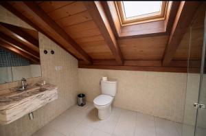 a bathroom with a toilet and a sink and a window at hostal Saint James Way in Cacabelos