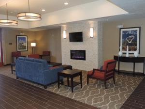 a waiting room with a couch and chairs and a fireplace at Heartland Inn and Suites in Wheatland