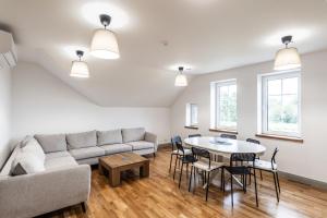 a living room with a couch and a table and chairs at Villa Asta in Rusnė
