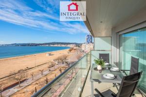 a balcony with a table and chairs and a beach at Paradís Platja Apartment in Palamós