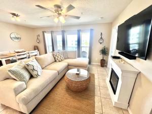 a living room with a couch and a flat screen tv at 3rd Floor Spacious Condo Close To Entertainment Shared pool Wifi in Navarre