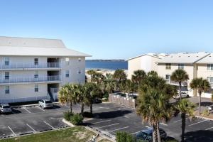 a view of a building and a parking lot with palm trees at 3rd Floor Spacious Condo Close To Entertainment Shared pool Wifi in Navarre