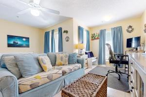 a living room with a couch and a desk at Spacious Condo with Balcony in Navarre Beach with Shared Pool in Navarre