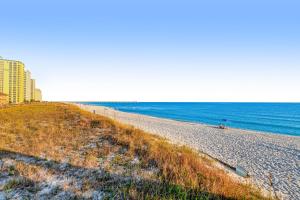 a sandy beach with a building and the ocean at Spacious Condo with Balcony in Navarre Beach with Shared Pool in Navarre