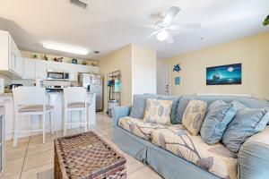 a living room with a blue couch and a kitchen at Spacious Condo with Balcony in Navarre Beach with Shared Pool in Navarre +28 photos