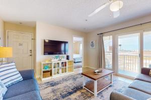 a living room with a couch and a tv at Bright condo with shared pool beach access & central location in Navarre