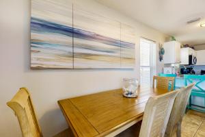 a dining room table with chairs and a painting on the wall at Bright condo with shared pool beach access & central location in Navarre