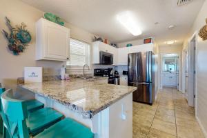 a kitchen with a counter top and a refrigerator at Bright condo with shared pool beach access & central location in Navarre +17 photos