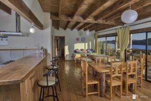 cocina y comedor con mesa de madera y sillas en Antuquelen Lodge Cabañas, en Frutillar