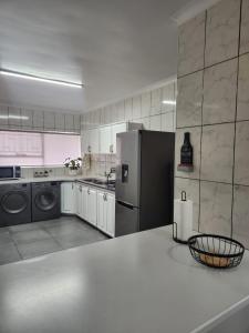 a kitchen with a refrigerator and a dishwasher at Ocean Sands Accommodation in Richards Bay