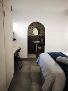 a bedroom with a bed and a bathroom with a sink at Ocean Sands Accommodation in Richards Bay +18 photos