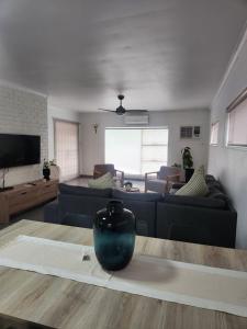 a living room with a couch and a vase on a table at Ocean Sands Accommodation in Richards Bay