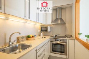 a kitchen with white cabinets and a sink at Paradís Platja Apartment in Palamós +26 photos
