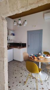 a kitchen with a table and chairs in a room at Convers'Amo Home in Conversano