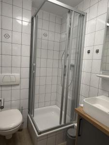 ein Badezimmer mit Dusche, Toilette und Waschbecken in der Unterkunft Schmidt-einander in Norderney