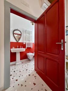 a bathroom with a red door and a sink at Convers'Amo Home in Conversano +22 photos