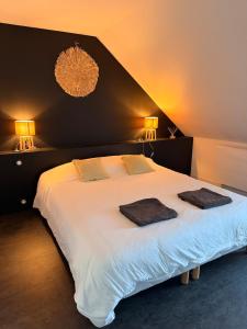 a bedroom with a large bed with two towels on it at Granville appartement in Granville