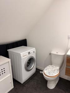 a bathroom with a washing machine and a toilet at Granville appartement in Granville