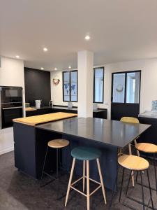 a kitchen with a large table and stools at Granville appartement in Granville +1 photo