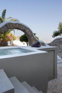 a swimming pool with a stone wall around it at The Dimora by Mazera in Ornos