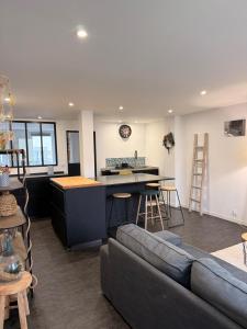 a living room with a couch and a kitchen at Granville appartement in Granville