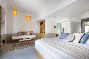 a bedroom with two beds and a bench in it at The Dimora by Mazera in Ornos +66 photos