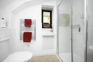 a white bathroom with a toilet and a shower at Speuran Mora in Teangue +15 photos