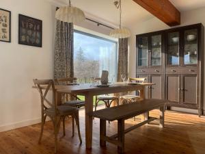 a dining room with a table and chairs and a window at Speuran Mora in Teangue
