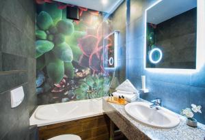 a bathroom with a sink and a tub and a toilet at Hotel Gottwald in Tata