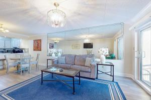 a living room with a couch and a table at Spacious 3rd-floor beachfront condo with stunning views pool pickleball & AC in Fort Walton Beach