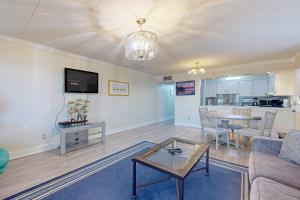 a living room with a couch and a table at Spacious 3rd-floor beachfront condo with stunning views pool pickleball & AC in Fort Walton Beach
