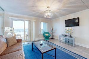 a living room with a couch and a tv at Spacious 3rd-floor beachfront condo with stunning views pool pickleball & AC in Fort Walton Beach