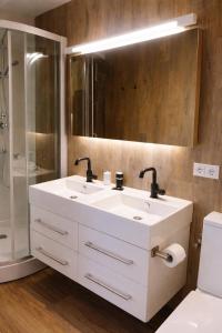 a bathroom with a white sink and a shower at Tiny House in Heerewaarden
