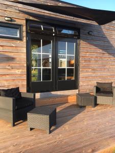a building with a deck with chairs and a window at Tiny House in Heerewaarden