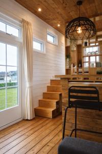 a room with stairs and a table and a window at Tiny House in Heerewaarden