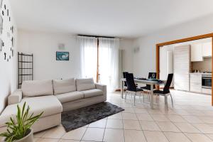 a living room with a white couch and a table at Residenza Quadrifoglio in Cesena