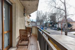 a balcony with two wooden chairs and a street at Residenza Quadrifoglio in Cesena