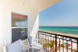 a balcony with two chairs and a view of the beach at Comfortable 6th-floor beachfront condo with ocean views - walkable locale in Fort Walton Beach