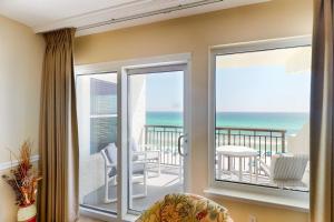 a living room with a sliding glass door with a view of the ocean at Comfortable 6th-floor beachfront condo with ocean views - walkable locale in Fort Walton Beach