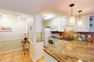 a kitchen with white cabinets and a counter top at Comfortable 6th-floor beachfront condo with ocean views - walkable locale in Fort Walton Beach