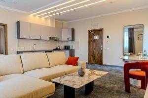 a living room with a couch and a table at Infinity Plaza Hotel Block 1 in Atyrau