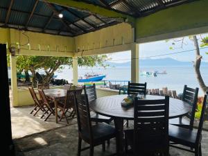a patio with tables and chairs and a view of the ocean at Bunaken Scuba Guest House in Bunaken