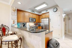 a kitchen with wooden cabinets and a counter top at First Floor Condo with a Partial Gulf View Splash Pad and More in Fort Walton Beach