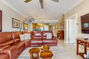 a living room with a brown leather couch at Roomy beachfront condo with full kitchen shared pool and beach access in Fort Walton Beach